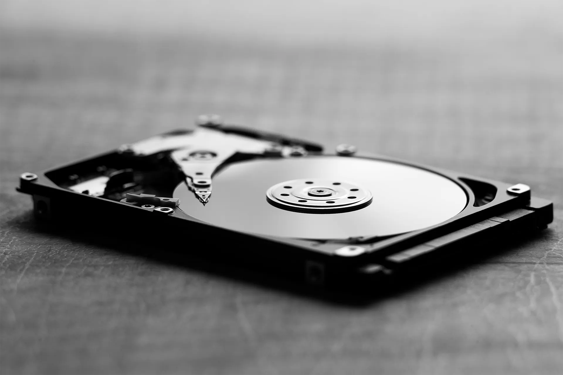 Binnenkant van een HDD met ronde magnetische schijf en leesarm